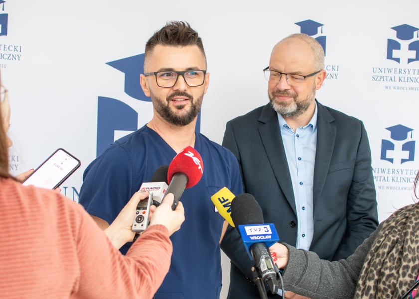 Na zdjęciu dwóch męzczyzn, jeden w lekarskim uniformie. Od lewej: Andrzej Mędrala, ratownik i pielęgniarz koordynujący w SOR USK we Wrocławiu i lek. Maciej Kamiński, wicedyrektor ds. medycznych USK we Wrocławiu