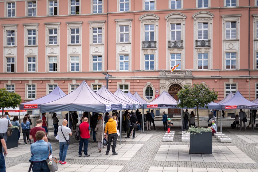 Kolejka przed budynkiem Urzędu Miejskiego Wrocławia na placu Nowy Targ, ustawiona z zachowaniem bezpiecznych odległości.