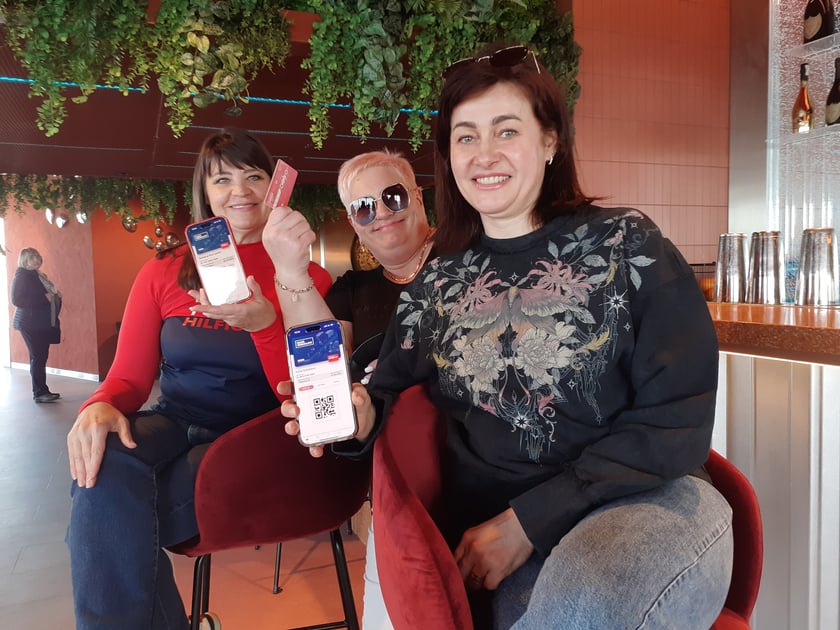 Irena, Halina i Tatiana pokazują aplikację Nasz Wrocław i kartę miejską Urbancard (Nasz Wrocław) w barze na 49. piętrze Sky Towera&nbsp;