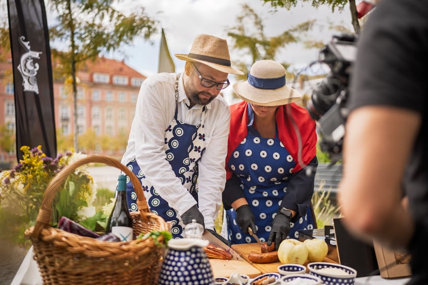 Kamila Kokot i Tomasz Sielicki pokazują, jak zrobić kapustę po wrocławsku. Zdjęcie wykonano 25 sierpnia 2025 na placu Nowy Targ, podczas kręcenia filmu.