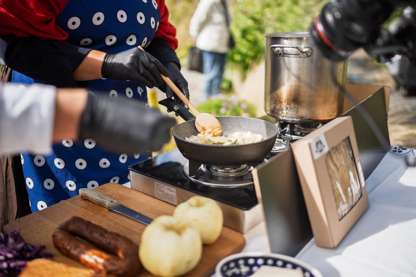 Kamila Kokot i Tomasz Sielicki pokazują, jak zrobić kapustę po wrocławsku. Zdjęcie wykonano 25 sierpnia 2025 na placu Nowy Targ, podczas kręcenia filmu.