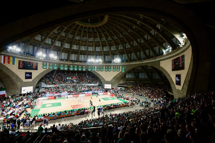 Powiększ obraz: Widok na wnętrze hali wypełnione kibicami  oraz boisko - mecz koszykówki w Hali Stulecia.