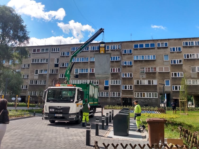 Wyciąganie podziemnego pojemnika na odpady na podwórku w okolicach pl. Nowy Targ i pl. Nankiera