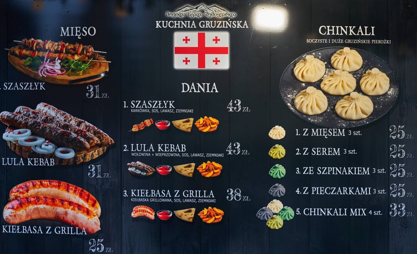Zdjęcia z Jarmarku Bożonarodzeniowego we Wrocławiu. Na zdjęciu widać tablicę z nazwami potraw i cenami
