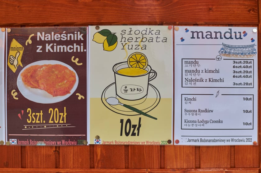 Zdjęcia z Jarmarku Bożonarodzeniowego we Wrocławiu. Na zdjęciu widać tablicę z nazwami potraw i cenami