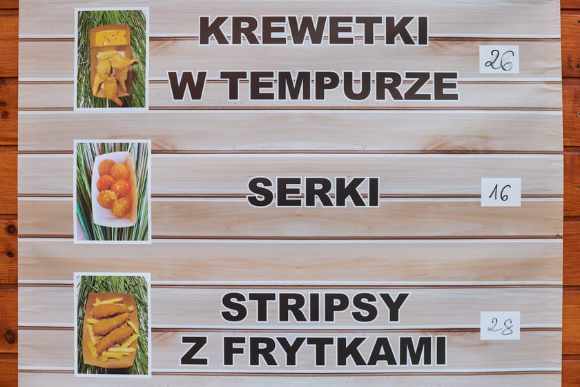 Zdjęcia z Jarmarku Bożonarodzeniowego we Wrocławiu. Na zdjęciu widać tablicę z nazwami potraw i cenami