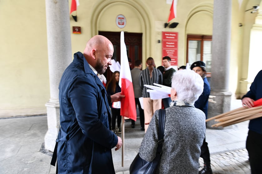 Prezydent Wrocławia Jacek Sutryk rozdaje flagi mieszkańcom i turystom.