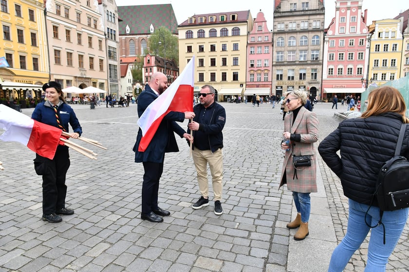 Prezydent Wrocławia Jacek Sutryk rozdaje flagi mieszkańcom i turystom.