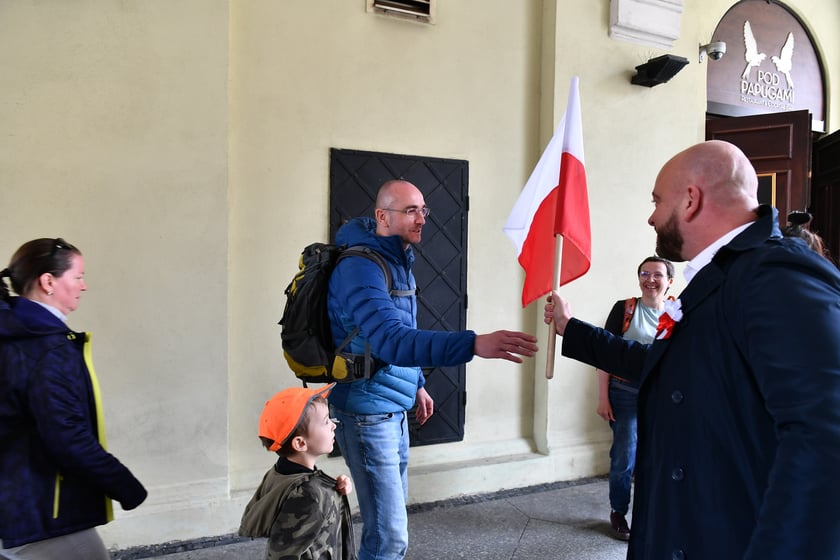 Prezydent Wrocławia Jacek Sutryk rozdaje flagi mieszkańcom i turystom.