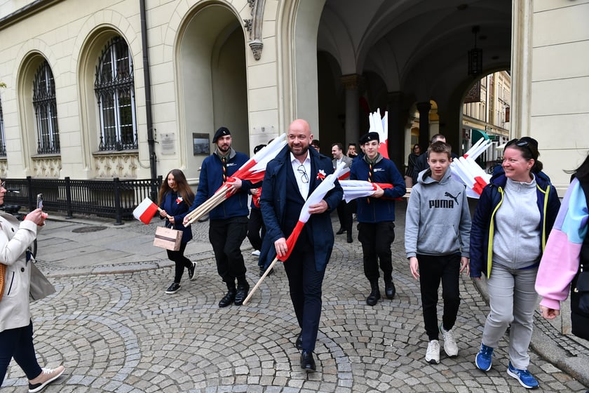 Prezydent Wrocławia Jacek Sutryk rozdaje flagi mieszkańcom i turystom.