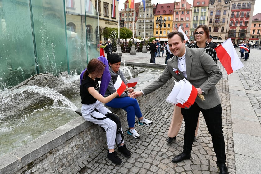 Prezydent Wrocławia Jacek Sutryk rozdaje flagi mieszkańcom i turystom.