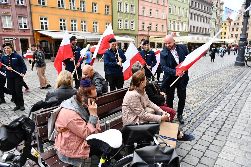 Prezydent Wrocławia Jacek Sutryk rozdaje flagi mieszkańcom i turystom.