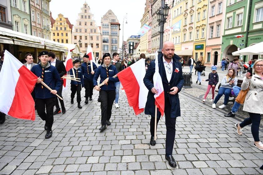 Prezydent Wrocławia Jacek Sutryk rozdaje flagi mieszkańcom i turystom.