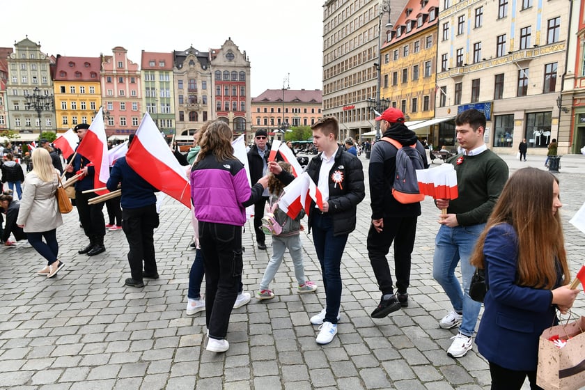 Prezydent Wrocławia Jacek Sutryk rozdaje flagi mieszkańcom i turystom.