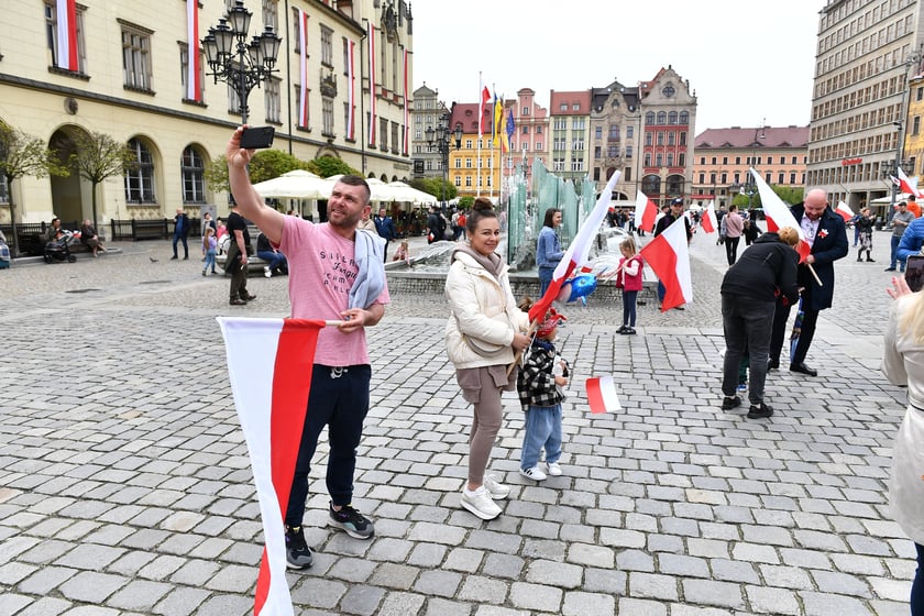 Prezydent Wrocławia Jacek Sutryk rozdaje flagi mieszkańcom i turystom.