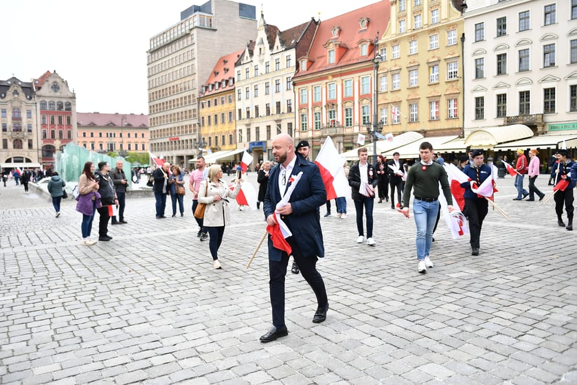 Prezydent Wrocławia Jacek Sutryk rozdaje flagi mieszkańcom i turystom.