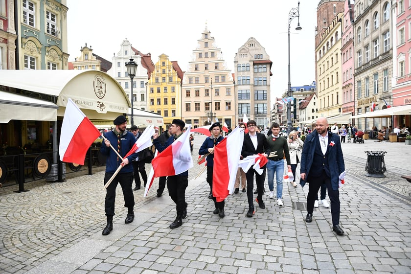 Prezydent Wrocławia Jacek Sutryk rozdaje flagi mieszkańcom i turystom.