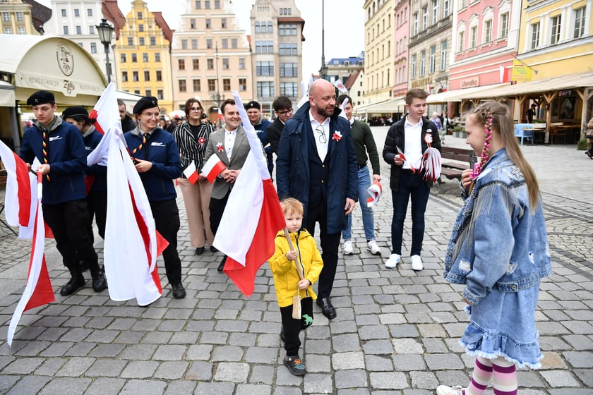Prezydent Wrocławia Jacek Sutryk rozdaje flagi mieszkańcom i turystom.