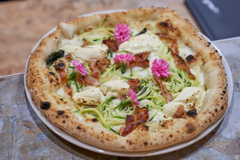 Olio
W Olio czeka na Was prawdziwa neapolitańska pizza. Jest naprawdę wyjątkowa, bo znalazła się w gronie TOP 50 sieci najlepszych pizzerii na świecie. W menu są też oczywiście przystawki, koktajle i rozgrzewające napary. Restauracja otworzyła się we Wrocławiu w grudniu 2023 roku.
Już od samego wejścia zachwyci Was swoim pięknym, przytulnym wnętrzem w stylu boho. Nie brakuje r&oacute;żu, kwiat&oacute;w i designerskich dodatk&oacute;w. Śmiało możemy powiedzieć, że jest nowym instagramowym hitem we Wrocławiu.
&ndash; Chcemy, żeby było u nas przytulnie, aby goście czuli się komfortowo. Uwielbiamy kontakt z ludźmi, każdy z nas jest uśmiechnięty, z dobrą energią. Lubimy po prostu gościć u nas gości i chcemy, żeby każdy gość po wyjściu miał w pamięci miłą atmosferę &ndash; m&oacute;wi Wiktoria Ciernia, manager restauracji.