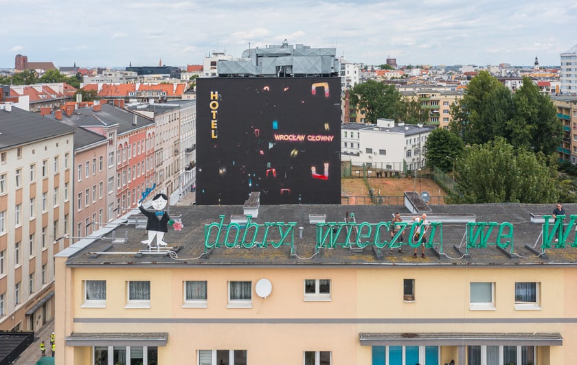 Zdejmowanie rurek z napisu i pana neonu "dobry wieczór we Wrocławiu"