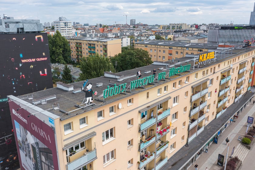 Zdejmowanie rurek z napisu i pana neonu "dobry wieczór we Wrocławiu"
