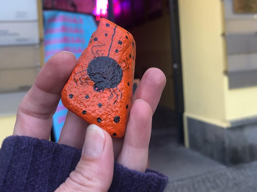 Malowany na pomarańczowo kamyk z pająkiem znaleziony na pl. Solnym we Wrocławiu