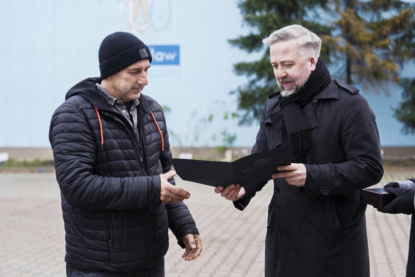 Radosław Michalski, dyrektor Departaentu Marki Wrocławia wręcza Andrzejowi Tylkowskiemu odznakę i list gratulacyjny prezydenta Jacka Sutryka