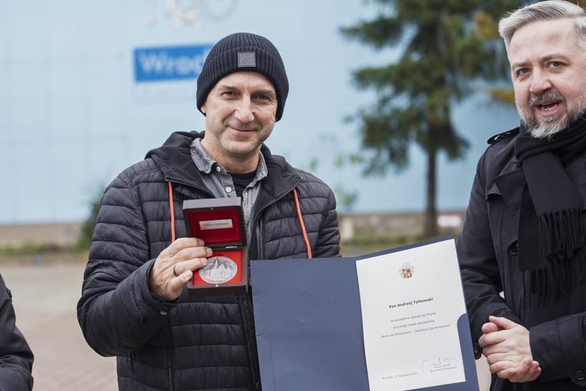 Radosław Michalski, dyrektor Departaentu Marki Wrocławia wręcza Andrzejowi Tylkowskiemu odznakę i list gratulacyjny prezydenta Jacka Sutryka