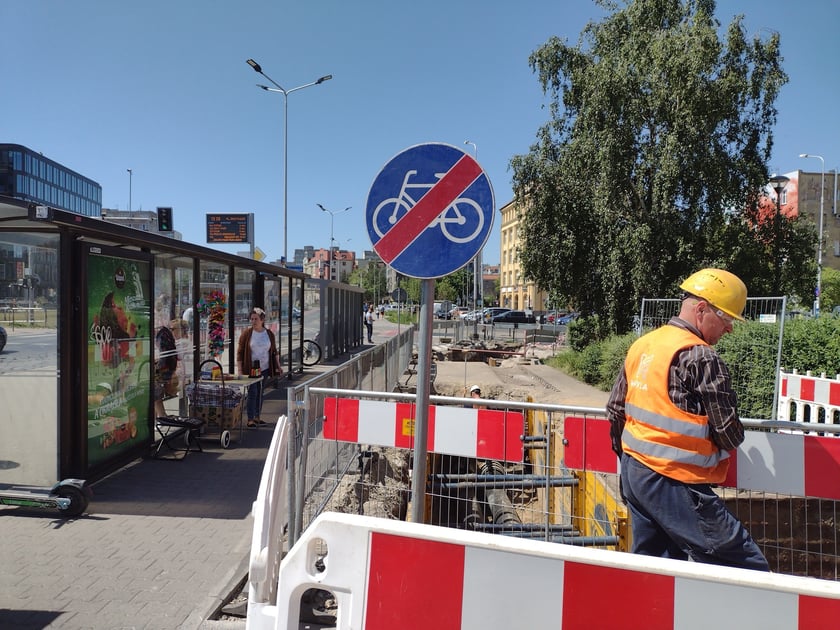 Głębokie wykopy w drodze rowerowej i plac budowy obok