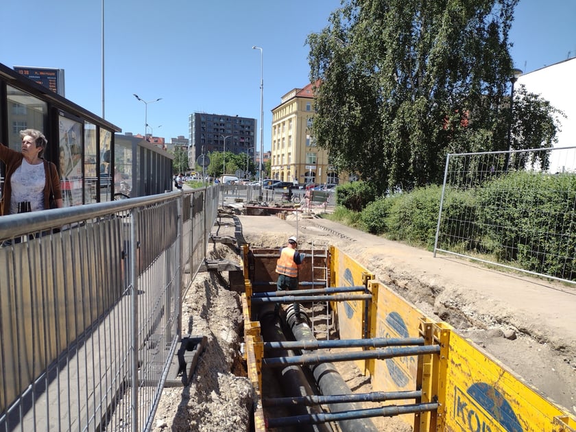 Głębokie wykopy w drodze rowerowej i plac budowy obok