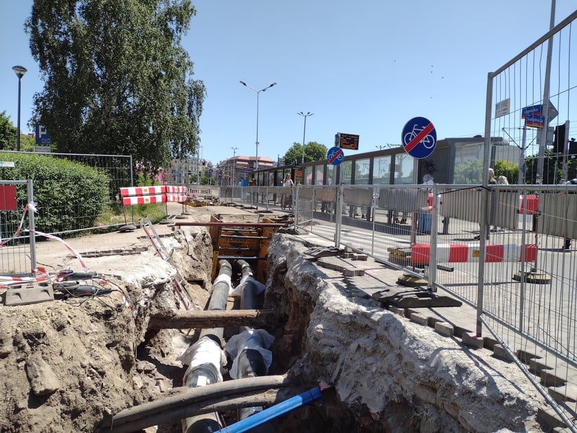 Głębokie wykopy w drodze rowerowej i plac budowy obok