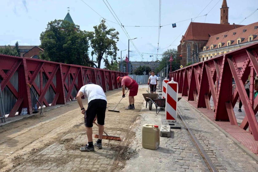 Kostka na moście jest już zaspoinowana. Trwa piaskowanie.