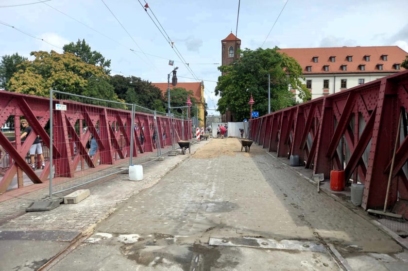 Kostka na moście jest już zaspoinowana. Trwa piaskowanie.