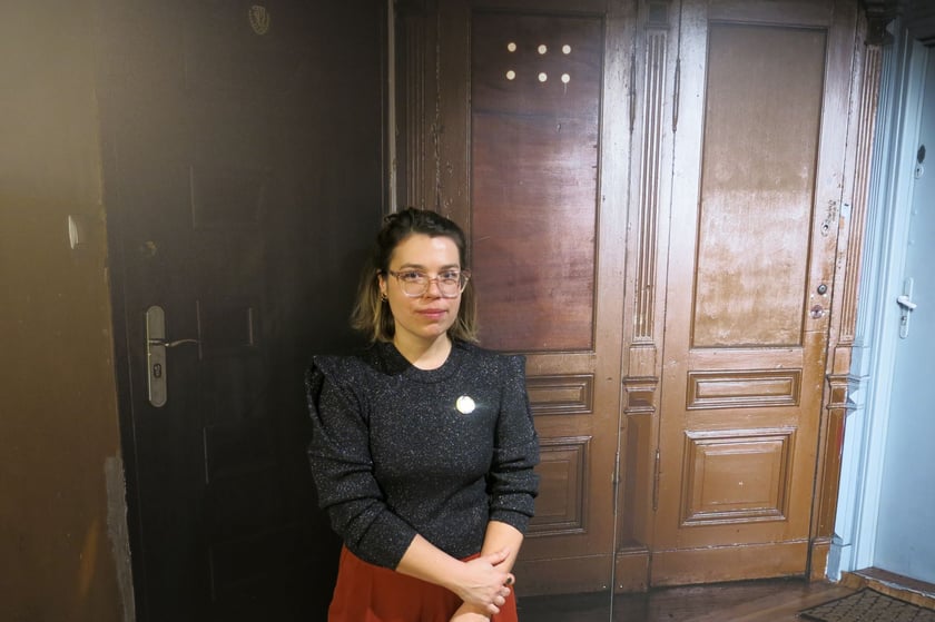 Współkuratorka wystawy Anna Kurpiel na tle zdjęcia drzwi na Przedmieściu Oławskim
