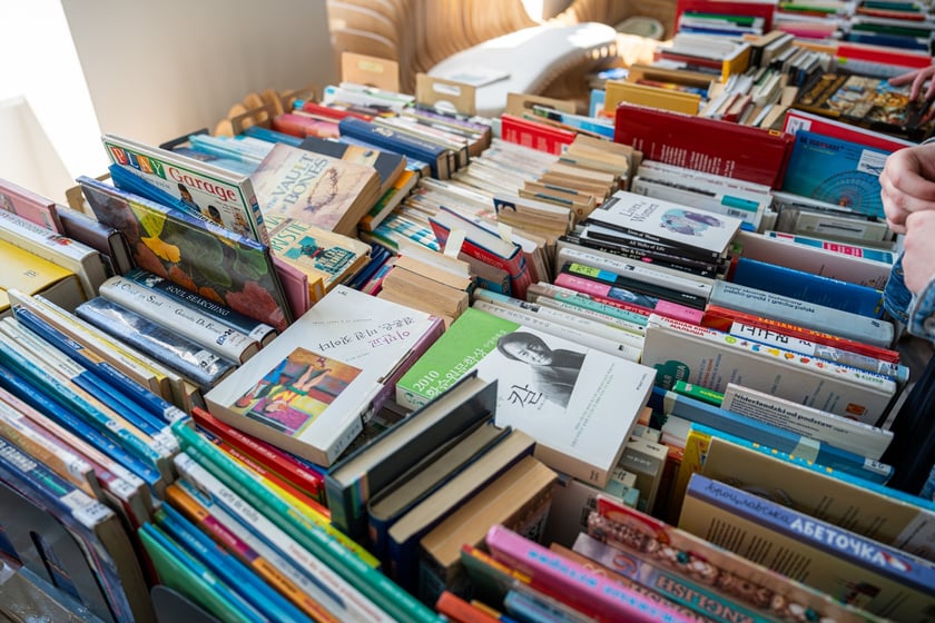 Czytelnicy przeglądający książki i inne zbiory wystawione na sprzedaż w Dolnośląskiej Bibliotece Publicznej w rynku