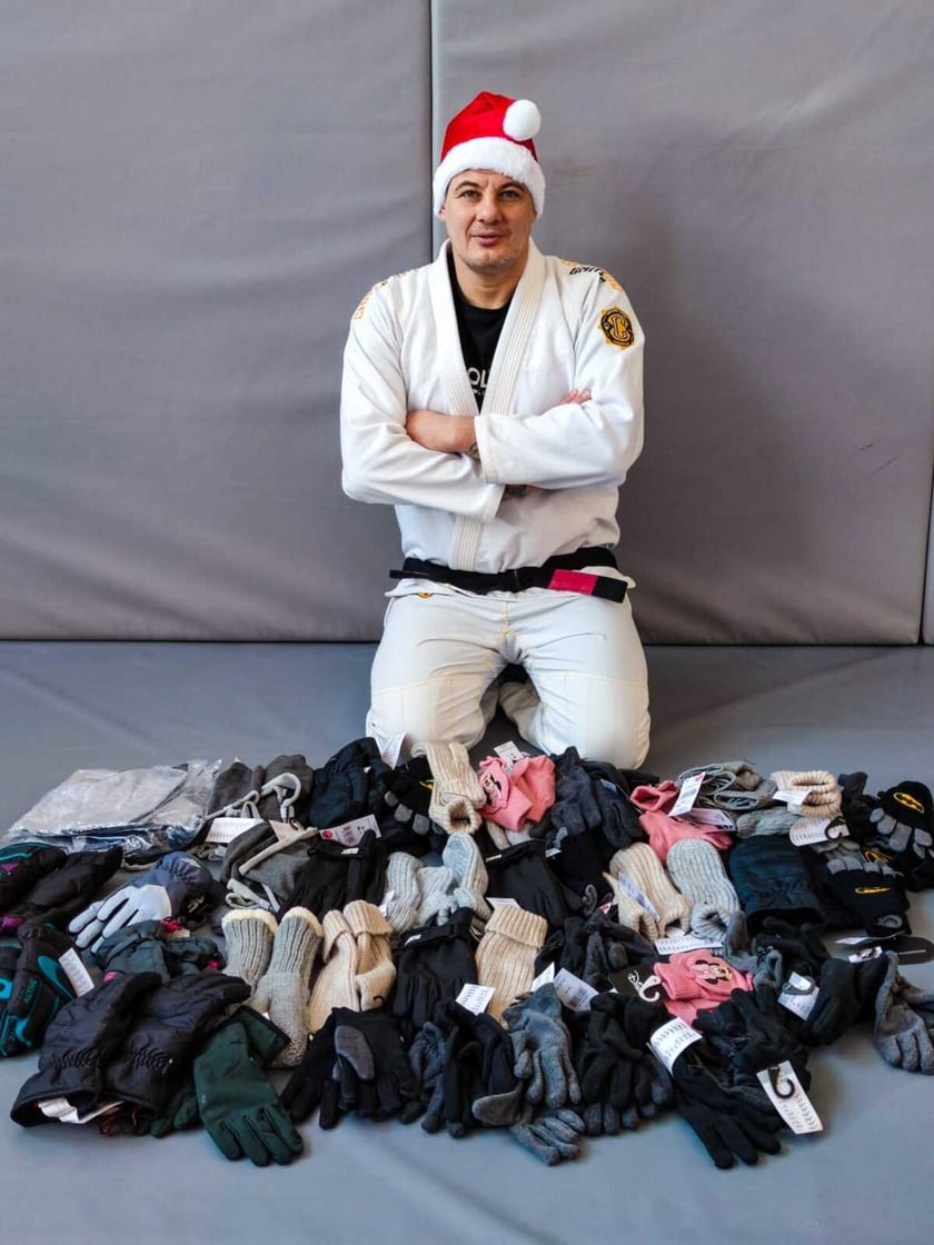 trener Paweł Szubart z rękawicami zimowymi dla dzieciaków, przyniesionymi przez wrocławian