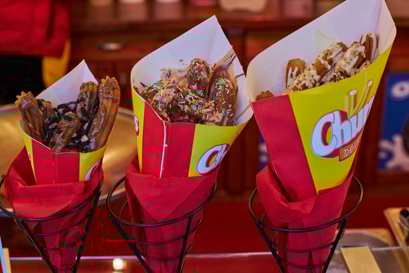 Zdjęcia z Jarmarku Bożonarodzeniowego we Wrocławiu. Na zdjęciu widać churrosy - hiszpański przysmak, który można kupić na Jarmarku Bożonarodzeniowym w Rynku.  Obok - podane są ceny. M.in. małe 18 złotych, duże 28 złotych.