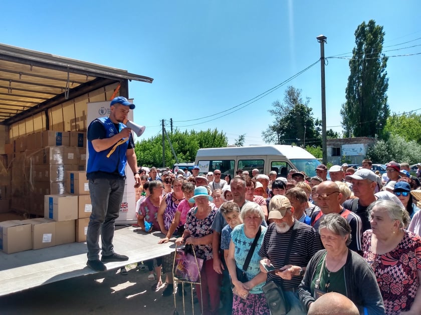 Jedna z os&oacute;b wydających paczki z megafonem