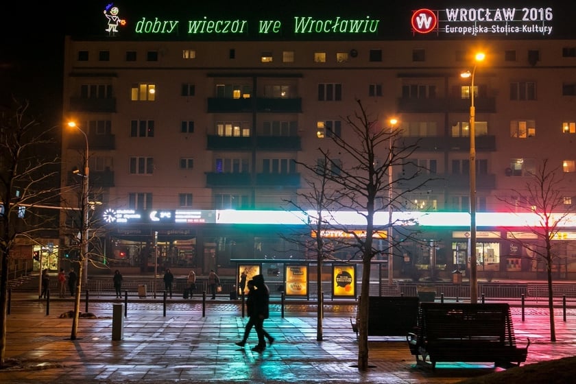 Wieczorny widok na budynek z neonem&nbsp;&bdquo;dobry wiecz&oacute;r we Wrocławiu&rdquo;, zdjęcie archiwalne