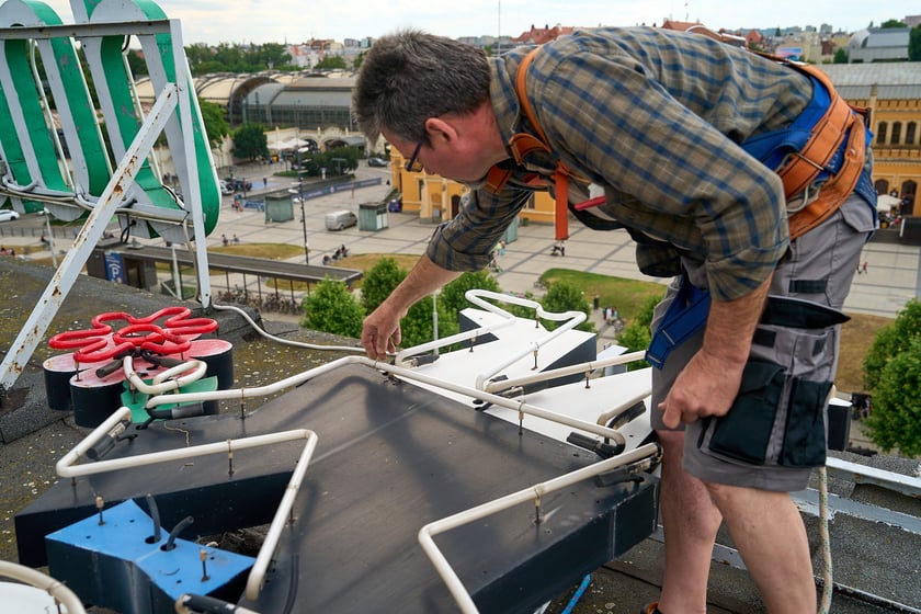 Zdejmowanie rurek z napisu i pana neonu "dobry wieczór we Wrocławiu"