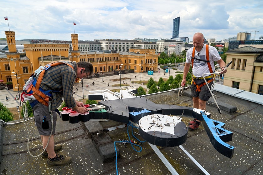 Zdejmowanie rurek z napisu i pana neonu "dobry wieczór we Wrocławiu"