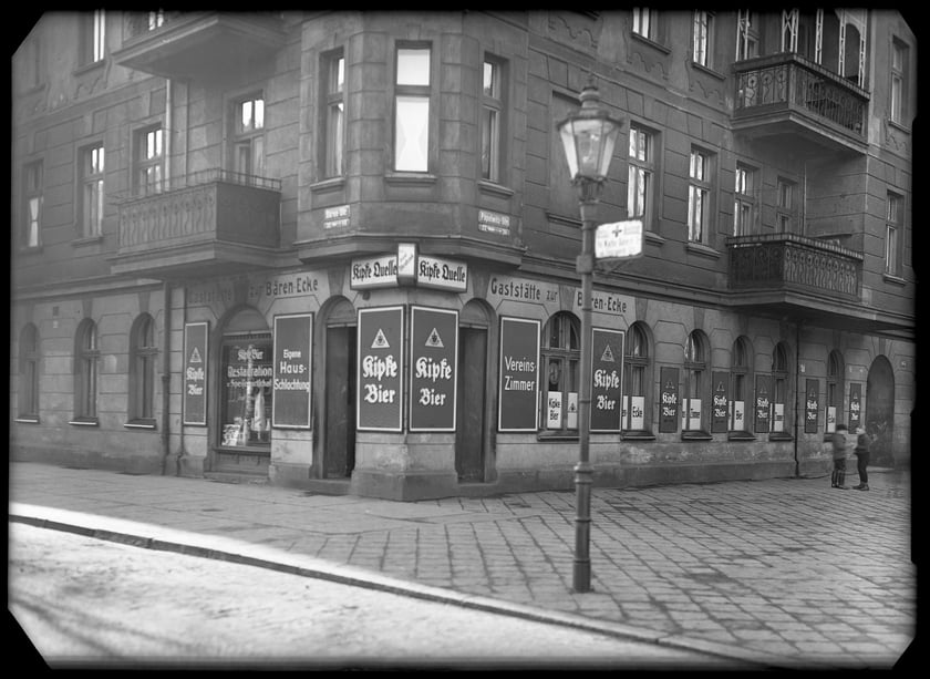Kamienica narożna na skrzyżowaniu ulic Niedźwiedziej i Popowickiej (B&auml;renstrasse i P&ouml;pelwitzstrasse). W Restauracji na Niedźwiedzim Narożniku (Gastst&auml;tte zur B&auml;ren-Ecke) można było zwilżyć gardło piwem od Kipkego.