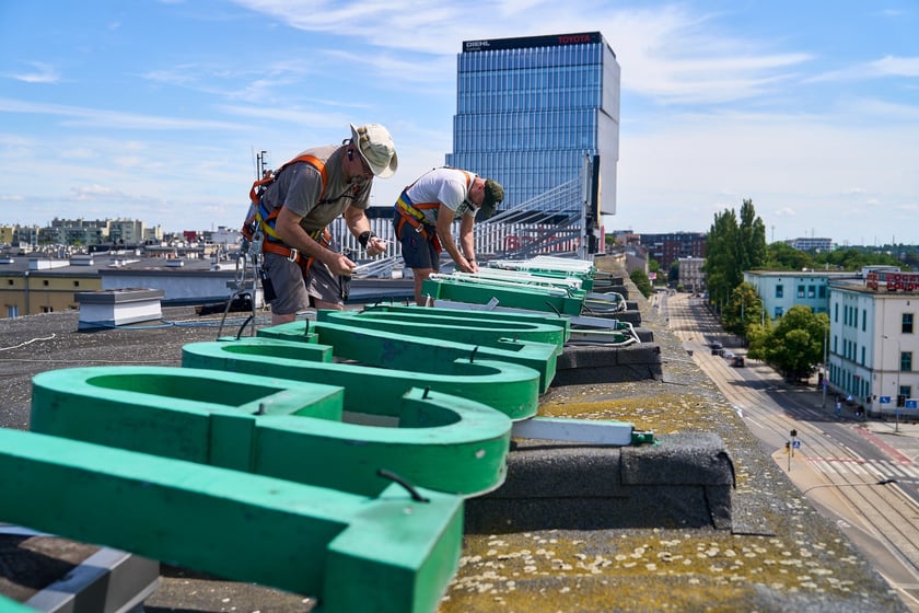Mocowanie szklanych rur neonu "dobry wieczór we Wrocławiu", 23 lipca 2024