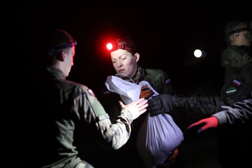 Kobiety i mężczyźni podczas akcji  na wale Janówek - Pracze. Trwa jego uszczelnianie