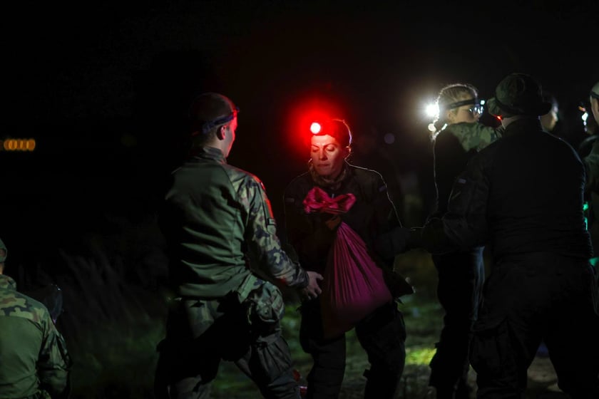 Kobiety i mężczyźni podczas akcji  na wale Janówek - Pracze. Trwa jego uszczelnianie