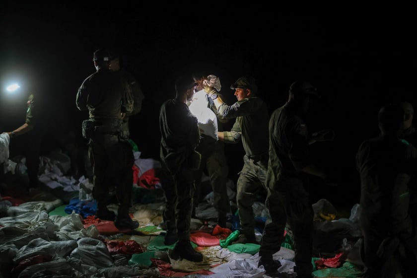 Kobiety i mężczyźni podczas akcji  na wale Janówek - Pracze. Trwa jego uszczelnianie