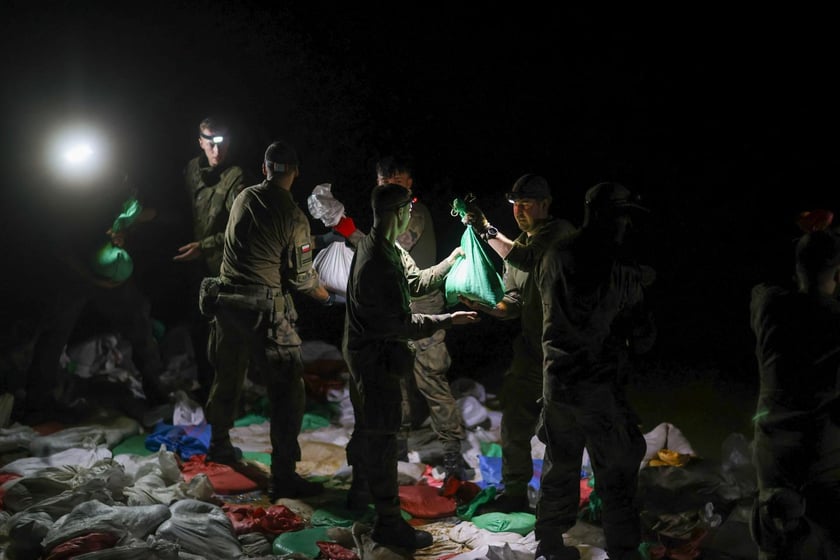 Kobiety i mężczyźni podczas akcji  na wale Janówek - Pracze. Trwa jego uszczelnianie