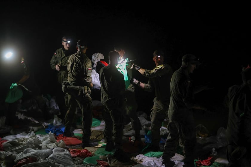 Kobiety i mężczyźni podczas akcji  na wale Janówek - Pracze. Trwa jego uszczelnianie