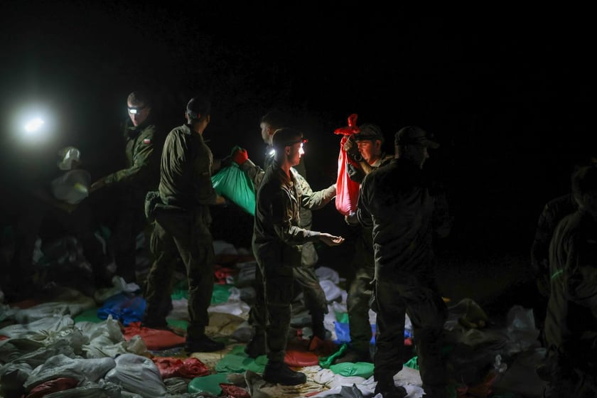 Kobiety i mężczyźni podczas akcji  na wale Janówek - Pracze. Trwa jego uszczelnianie