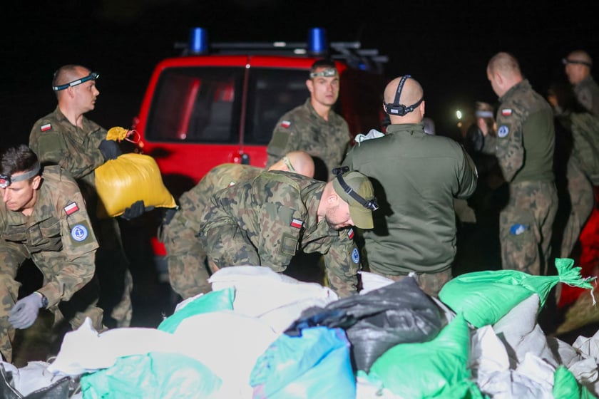 Kobiety i mężczyźni podczas akcji  na wale Janówek - Pracze. Trwa jego uszczelnianie